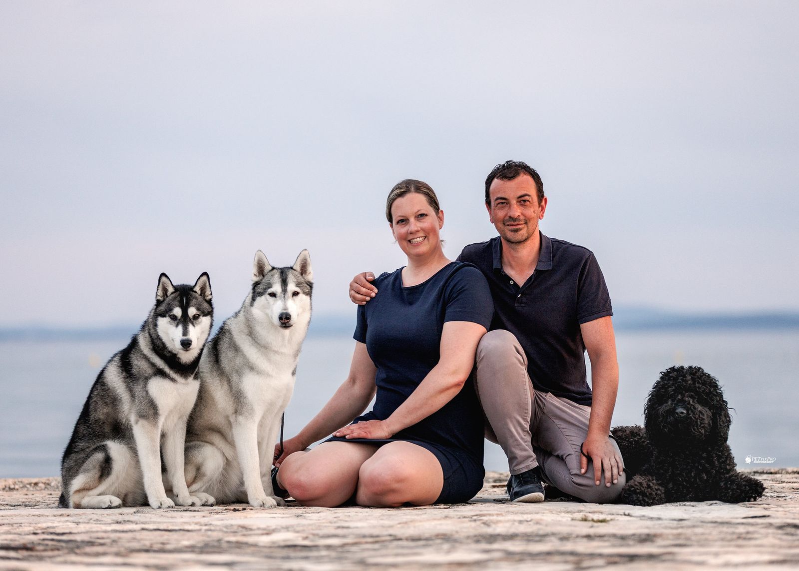 Das Züchterpaar von Joiel's Palace mit zwei Siberian Huskys und dem Barbet am Meer